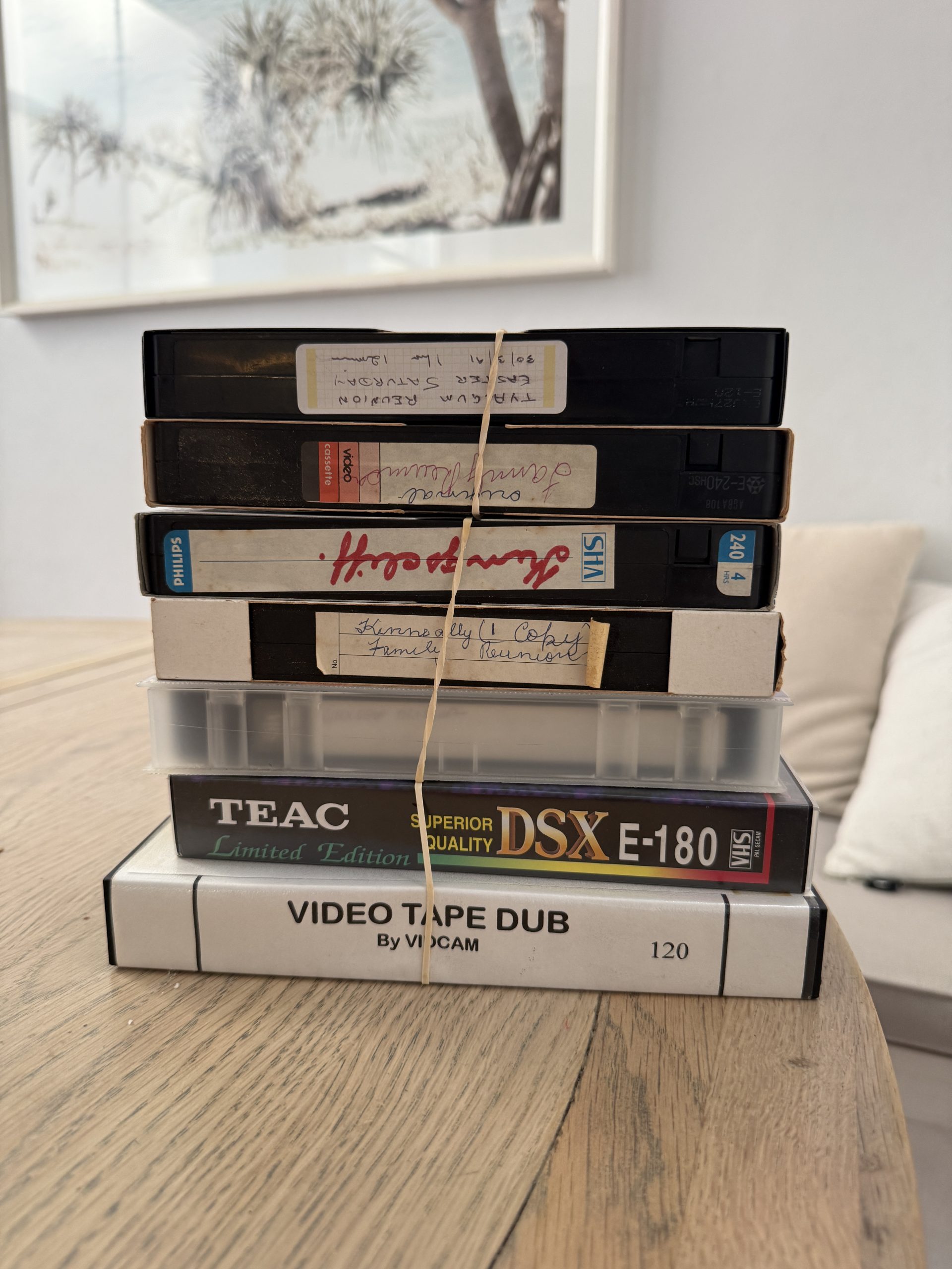 Stack of old VHS tapes bundled with rubber band ready for digital transfer by That TV Guy on the Northern Beaches