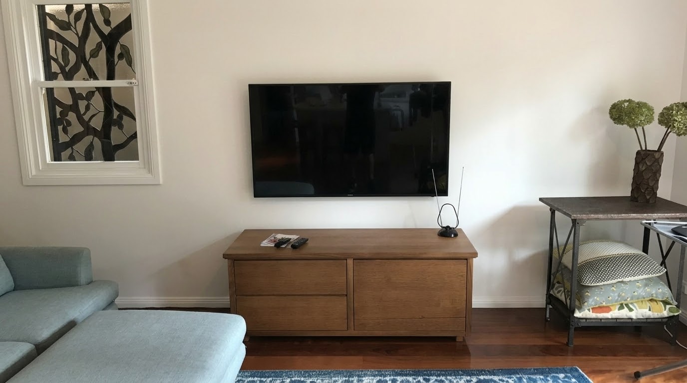 55-inch Samsung TV wall mount in Artarmon, North Shore, above a timber credenza with cables hidden in the wall and an indoor antenna